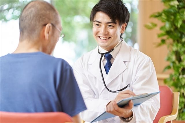 往診を行う医師と高齢男性患者